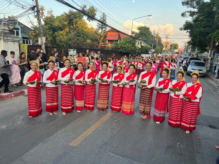 Vrouwen in traditionele Thaise kleding met offerschaaltjes tijdens een processie