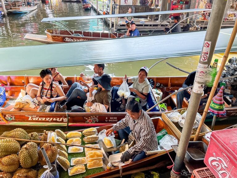 Verkoopster met durian vanuit haar boot op de drijvende markt